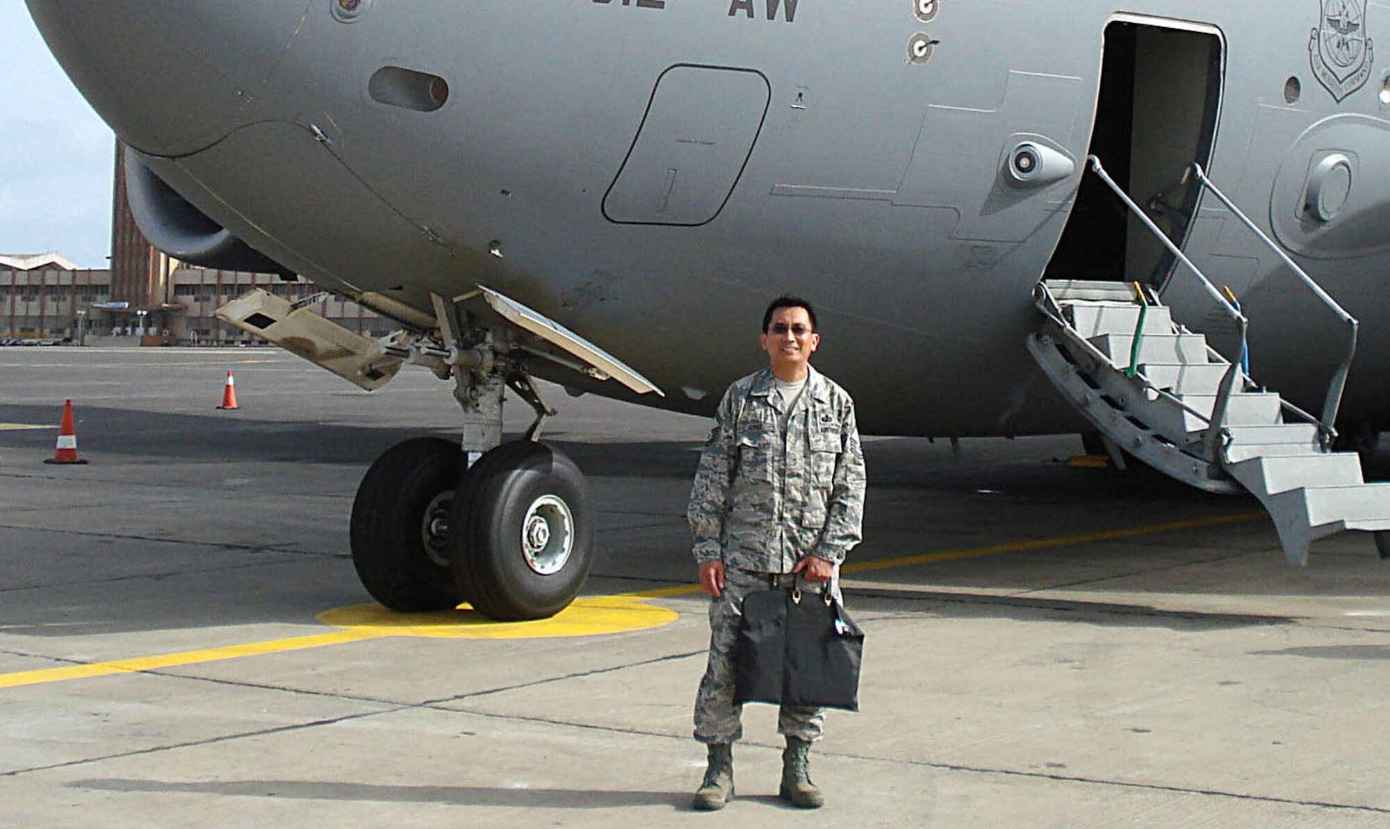 SENEGAL - Senior Master Sgt. Alfredo Cruz, stands in front of a C-17 Globemaster III aicrraft, reading to execute his paying agent tasks. Sergeant Cruz deployed to Senegal this past summer in support of the exercise Silver Eagle. Sergeant Cruz's job as paying agent entailed making sure all navigation and landing fees required upon arrival to a foreign country are paid. (Photo courtesy Senior Master Sgt. Alfredo Cruz)                    