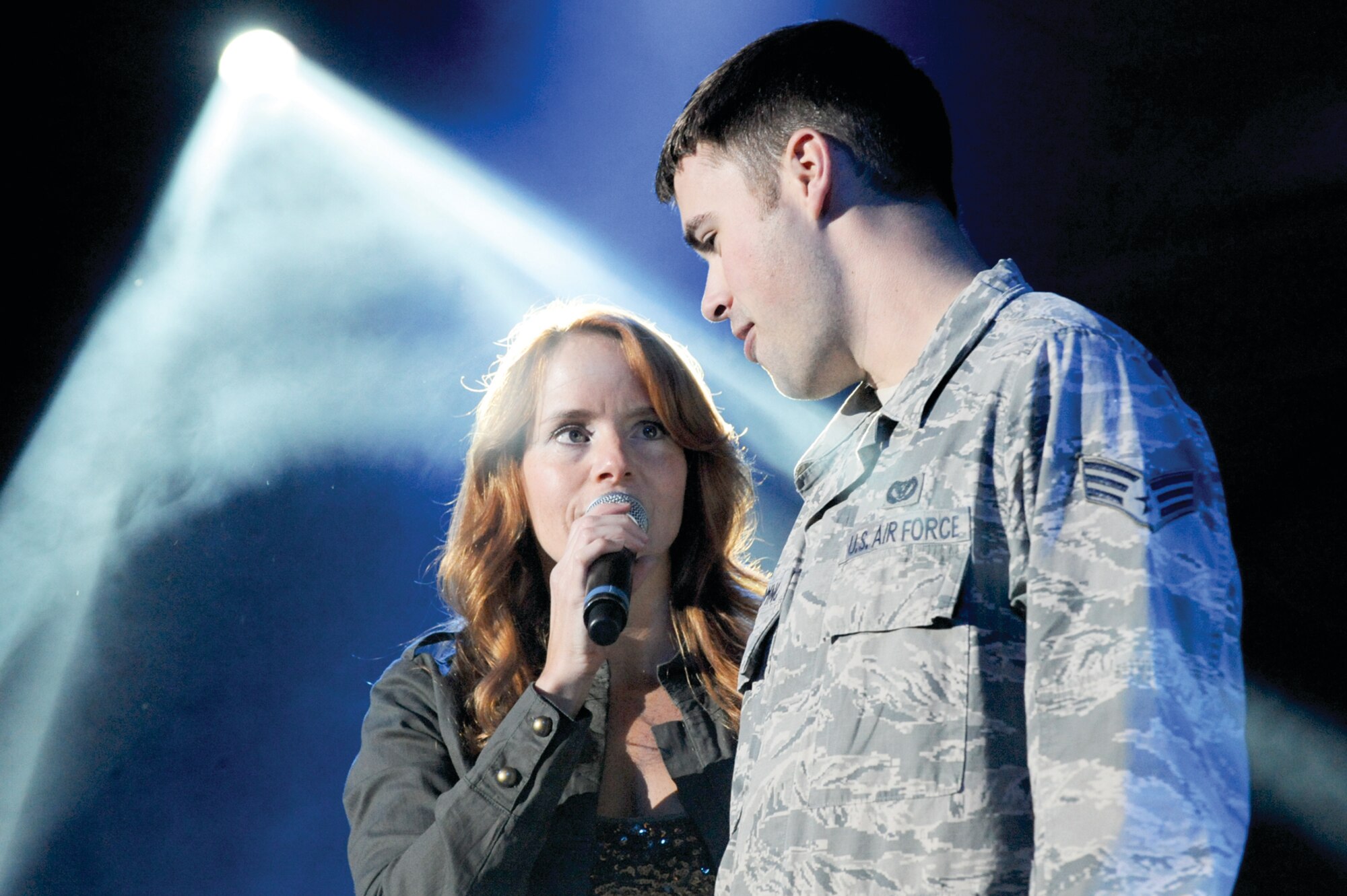Female vocalist Julie Dutchak, serenades Senior Airman Christopher Dominck, 773d Civil Engineering Squadron, on stage during the Lieutenant Dan Band performance, Sept. 16. The band played cover songs to a standing audience at Hangar 20 for more than and hour and a half. (Photo by Air Force Staff Sgt. Joshua Garcia/JBER PAO)