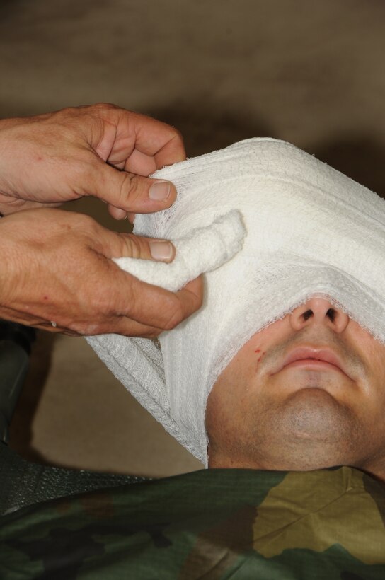 ELLSWORTH AIR FORCE BASE, S.D. -- Airman 1st Class Frederick Ferrante, Air Force Financial Services Center, reserve travel technician, has a simulated eye injury during a Phase II Operational Readiness Exercise, Sept. 16.  Self-aid buddy care is a crucial ability tested during the exercise. (U.S. Air Force photo/Airman 1st Class Anthony Sanchelli)
