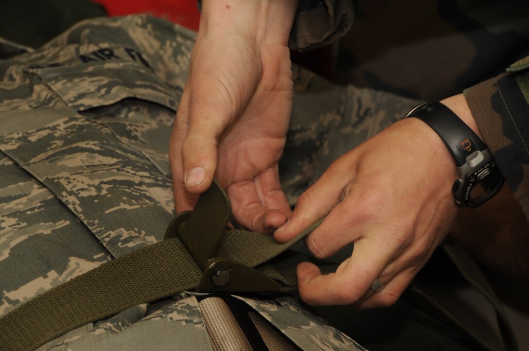 ELLSWORTH AIR FORCE BASE, S.D. -- Airman 1st Class David McMillen, 28th Civil Engineer Squadron, heating, ventilation and air-conditioning apprentice, secures a simulated patient to a stretcher during a Phase II Operational Readiness Exercise, Sept. 16.  Airmen test their skills during the exercise in a simulated deployed environment. (U.S. Air Force photo/Airman 1st Class Anthony Sanchelli)
