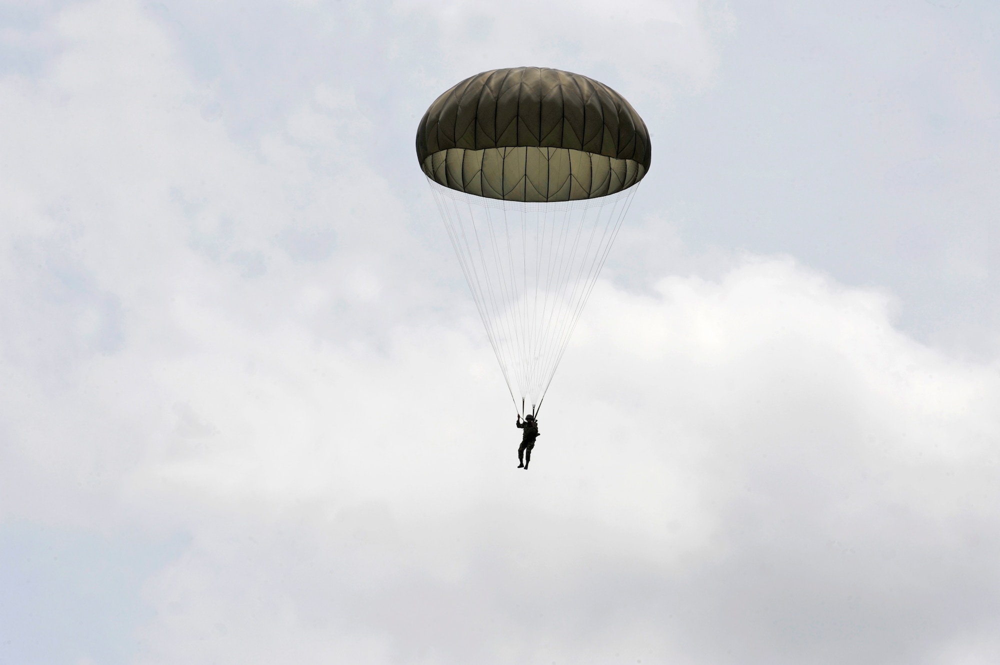 A Colombian military member parachutes to the ground after a static line jump from a Colombian C-130 Hercules Sept. 16, 2010, at Palanquero Air Base, Colombia. They successfully completed three static line and high-altitude, low-opening jumps during an exercise in which U.S. and Colombian aircrews exchanged information. (U.S. Air Force photo)