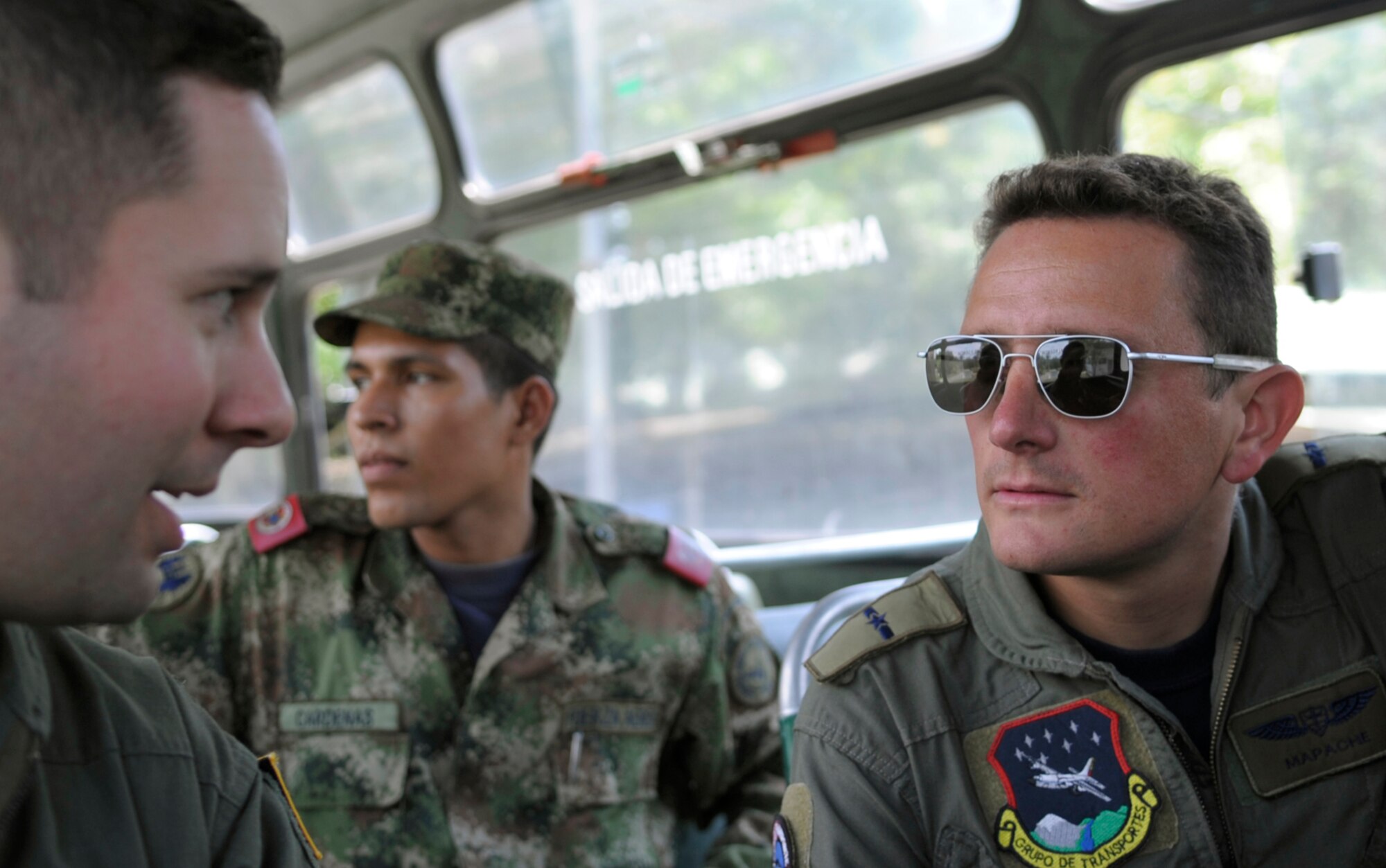 Mayor (Maj.) Eduardo 'Mapache' Restrepo, (right), talks to Capt. Ramon Fierros about the day's upcoming mission while riding a bus to a crew brief Sept. 16, 2010, at Palanquero Air Base, Colombia. Major Restrepo is a Colombian air force C-130 Hercules co-pilot. Captain Fierros is a C-130 navigator. (U.S. Air Force photo)