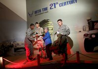 Milita Rios-Samaniego, Security Forces Museum director and curator, sets up the museum's newest exhibit, "Into the 21st Century," with the help of Airmen Dominiq Russell and Trevor Stinson, both from the 343rd Training Squadron, Sept. 13. (U.S. Air Force photo/Robbin Cresswell) 