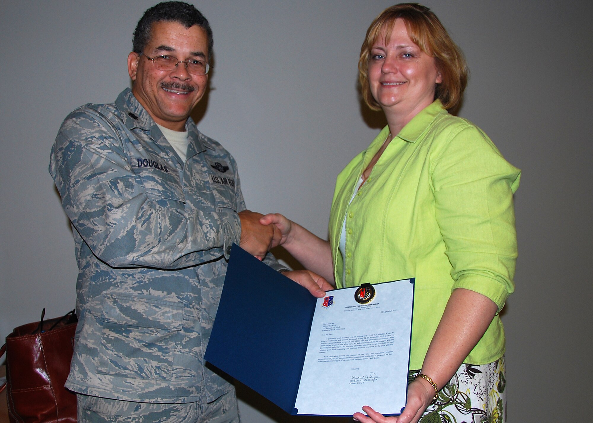 JOINT BASE MCGUIRE-DIX-LAKEHURST, N.J. ? Laura Bay, a human resource specialist from Air Force Reserve Command, receives a commander?s coin from Lt. Col. Raymond Douglas, 514th Air Mobility Wing executive officer, on behalf of Col. Giordano McMullen, 514 AMW commander, at the Combined Maintenance and Operations Facility auditorium here Sept. 23. Ms. Bay taught a class about time and attendance policies and procedures for Air Reserve Technicians and civilian Air Force Reserve employees. (U.S. Air Force photo/Staff Sgt. Shawn J. Jones)