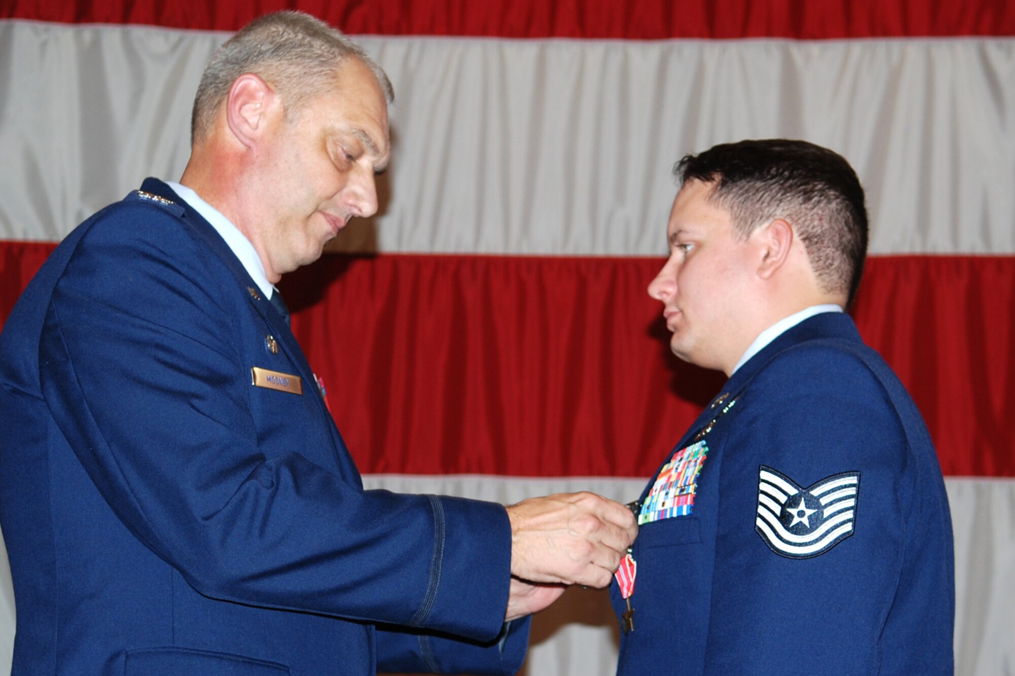 Col. John J. Mooney III, commander of the 917th Wing, pins an Air Force Combat Action Medal on Technical Sgt. Brett Vickers, 917th Explosive Ordnance Disposal (EOD) Flight, during award ceremonies in Hoban Hall at Barksdale Air Force Base, La., Sept. 12, 2010. Sergeant Vickers was awarded the medal for actions while deployed to the 755th Bravo EOD Flight in Afghanistan from Sept. 30, 2009 to March 31, 2010. (U.S. Air Force photo/Master Sgt. Greg Steele)
