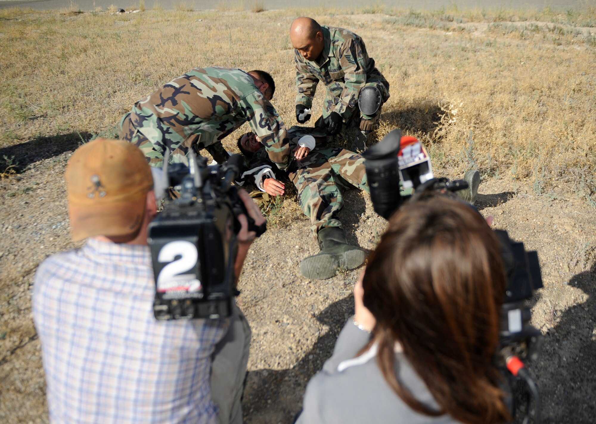 MOUNTAIN HOME AIR FORCE BASE, Idaho -- Brian Hild, KBOI CBS 2 Television photographer and Michelle Costa, KMVT News 11 reporter, captures footage of the 366th Medial Group performing self aid and buddy care during an exercise for media day Sept. 17. The goal of media day was to strengthen relationships with local media agencies and give access to the Airmen and mission of the base. (U.S. Air Force photo by Senior Airman Renishia Richardson)