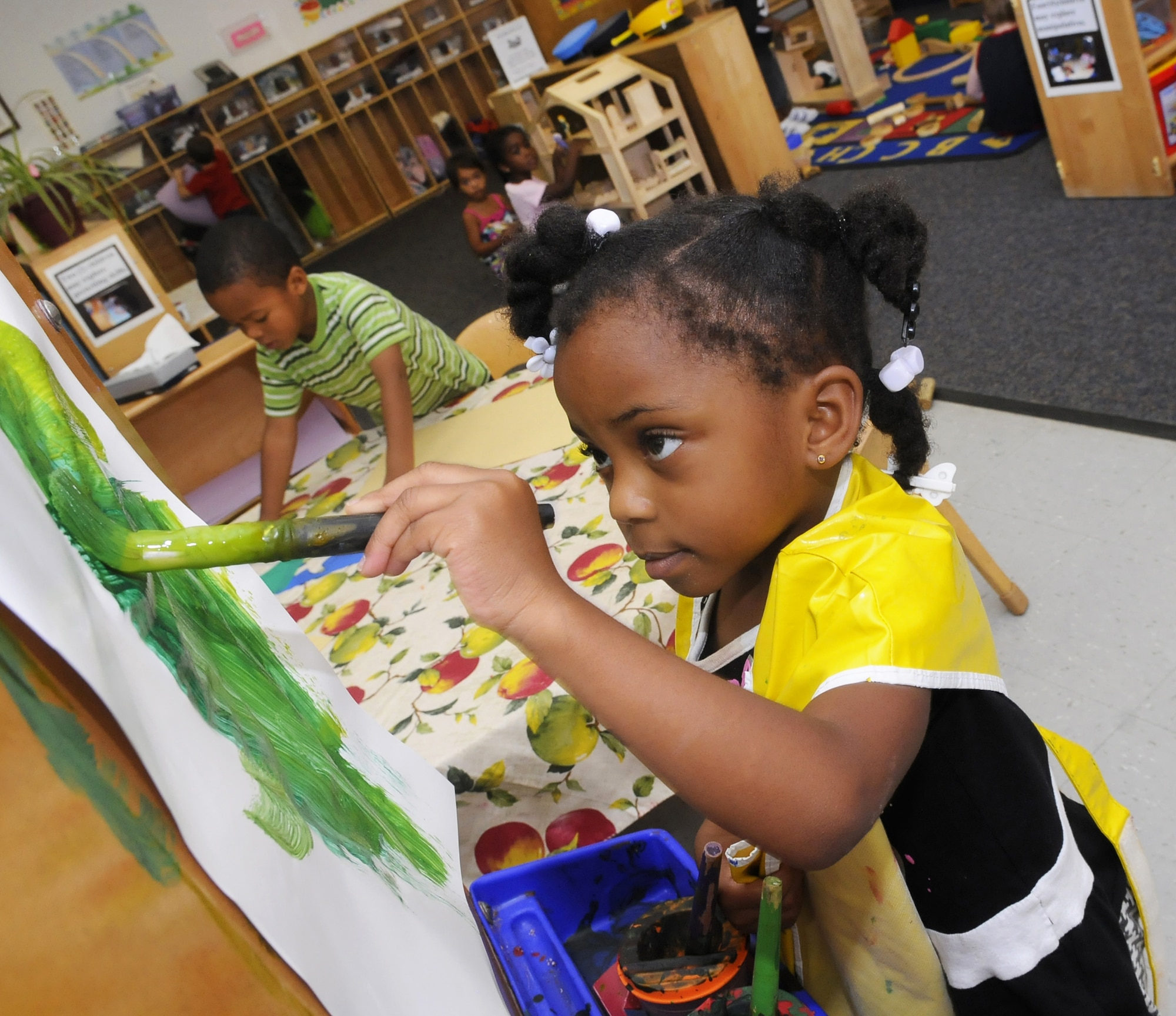 Brisha Smith paints at an easel in the 3-4 year old room at Child Development Center West. U. S. Air Force photo by Sue Sapp