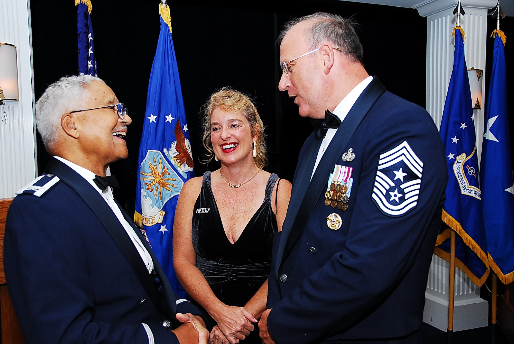Retired Col. Edward C. McGee, a member of the Tuskegee Airmen, left, enjoys a laugh with Command Master Sgt. Pat Battenberg, Air Force District Washington (AFDW), right, and Sherry Battenberg of Andrews Air Force Base, Md., center, during AFDW’s 2010 Air Force Ball, held at Bolling Air Force Base. (U.S. Navy photo by Joseph P Cirone/Released)    