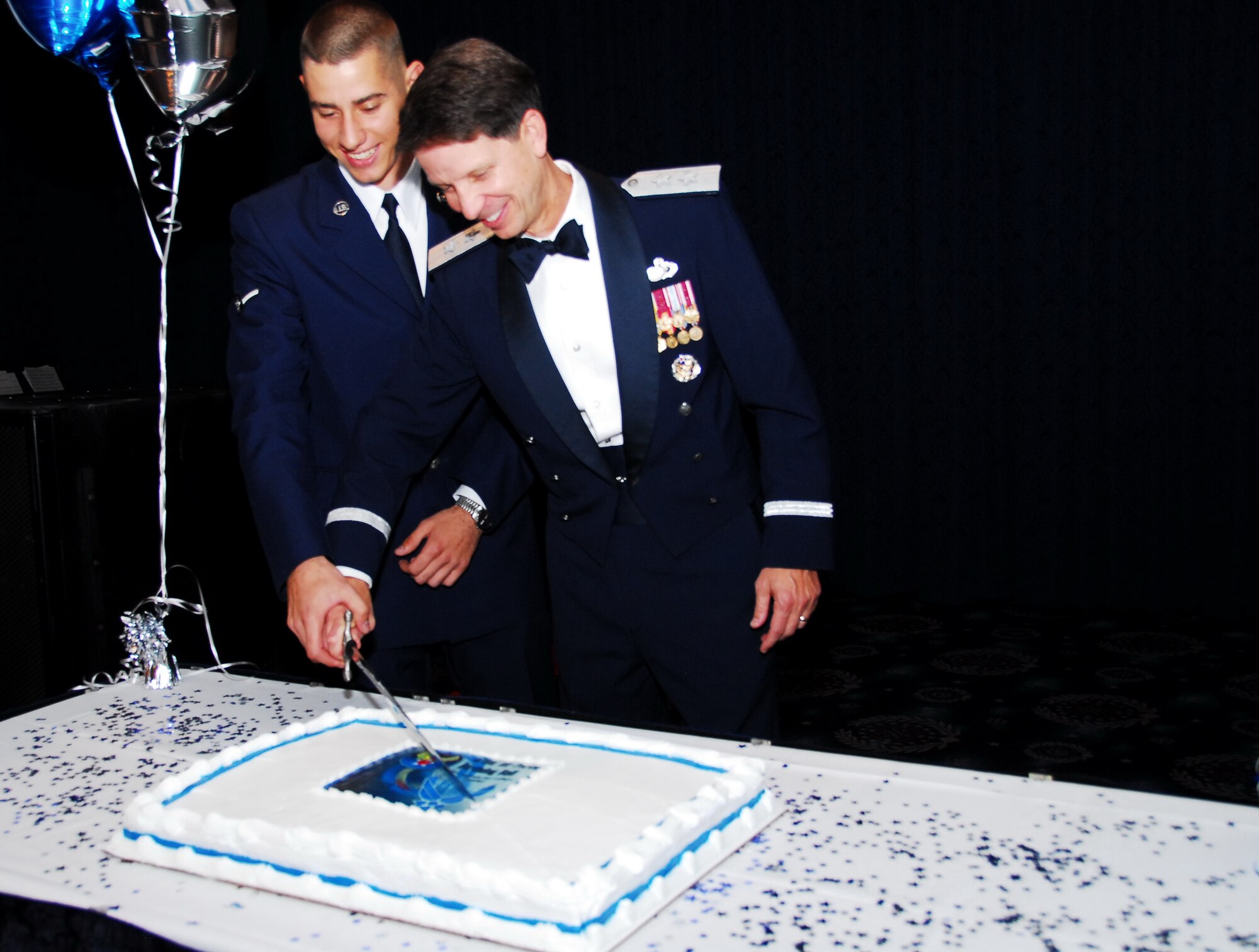 Commander, Air Force District Washington (AFDW) Maj. Gen. Darrell Jones, right, the most senior in rank at the ball and 11th Logistics Readiness Squadron Airman Peter Boosalis, originally of Bloomington Minn., the least senior in rank, share a ceremonial sword and cut the anniversary birthday cake at the 2010 Air Force Ball, held at Bolling Air Force Base (BAFB). (U.S. Navy photo by Joseph P Cirone/Released)    