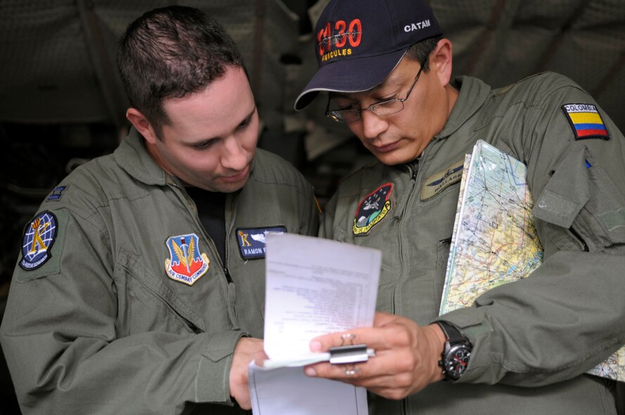 PALANQUERO AIR BASE, Colombia -- Mayor (Maj.) Jovanny ‘Wallace’ Sanchez Bolivar Wallace Colombian air force C-130 navigator and Capt. Ramon Fierros, U.S. Air Force C-130 navigator, go over the checklists prior to an airdrop of cargo Sept 15. here. The airdrop was a first for the Colombian aircrew and part of a weeklong subject matter expert exchange between U.S. and Colombian Air Force C-130 crews here. (U.S. Air Force photo/Staff Sgt. Andrea Thacker)
