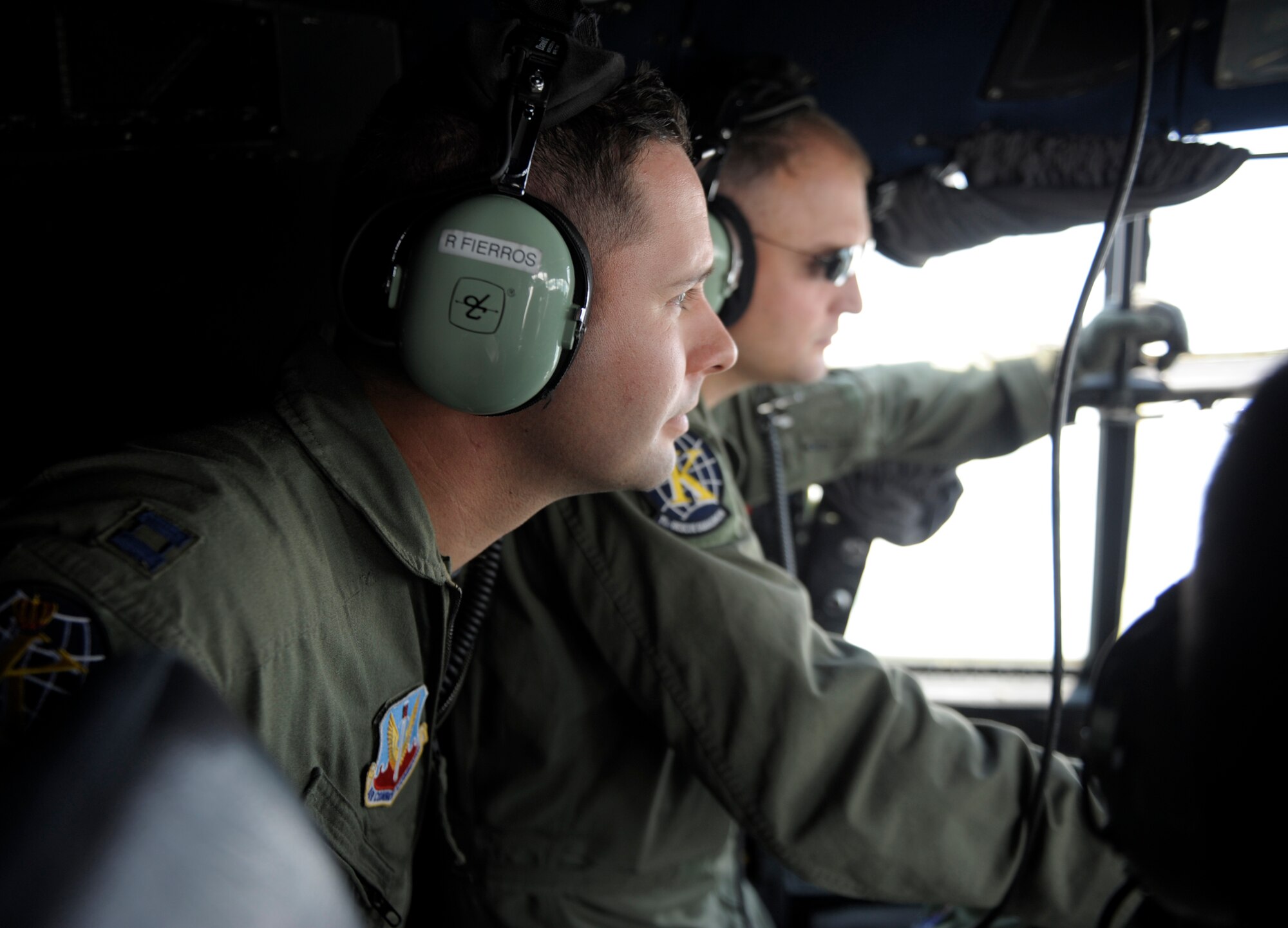 PALANQUERO AIR BASE, Colombia -- Capt. Ramon Fierros, (left) 71st Rescue Squadron C-130 navigator, and Maj. Jeremy Dickey, 71st Rescue Squadron HC-130 pilot, observe the flight deck of a Colombian C-130 during a flight over skies of central Colombia Sept. 14. The weeklong information exchange gave four of Moody Airmen the opportunity to observe and advise the Colombians on their day-to-day rescue operations such as personnel air drops, cargo drops, infiltration and exfiltration of military and civilian personnel.  