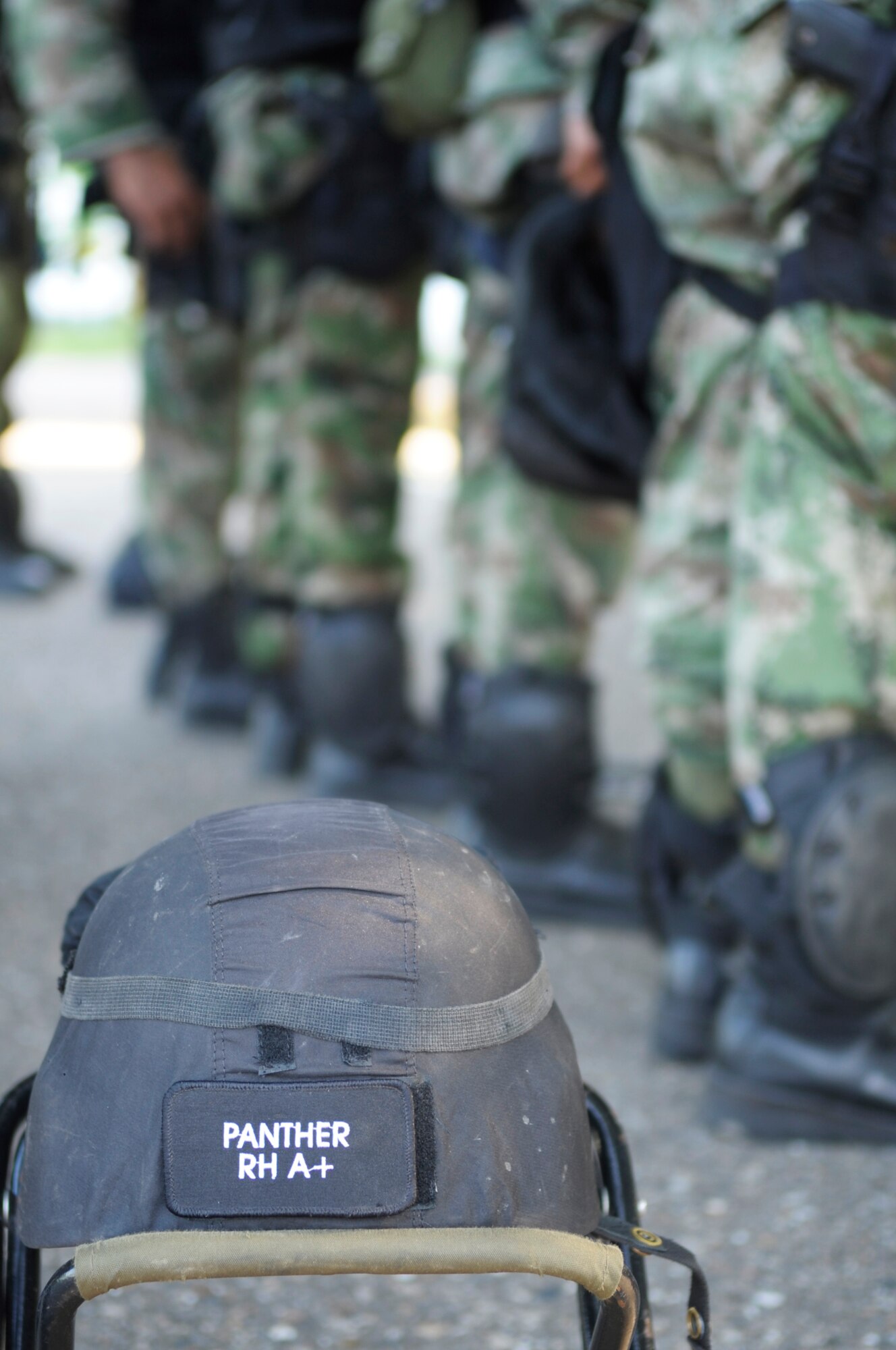 PALANQUERO AIR BASE, Colombia -- A helmet sits behind the formation of Colombian air force personnel as they receive a mission briefing from Lt. Col. Peter Dominicis, 347th Operations Support Squadron director of operations, Sept 14 here. Colonel Dominicis, a C-130 pilot of 17 years, was selected to attend a weeklong subject matter expert exchange between the U.S. and Colombian rescue communities because of his knowledge of the C-130 and his ability to speak fluent Spanish. 