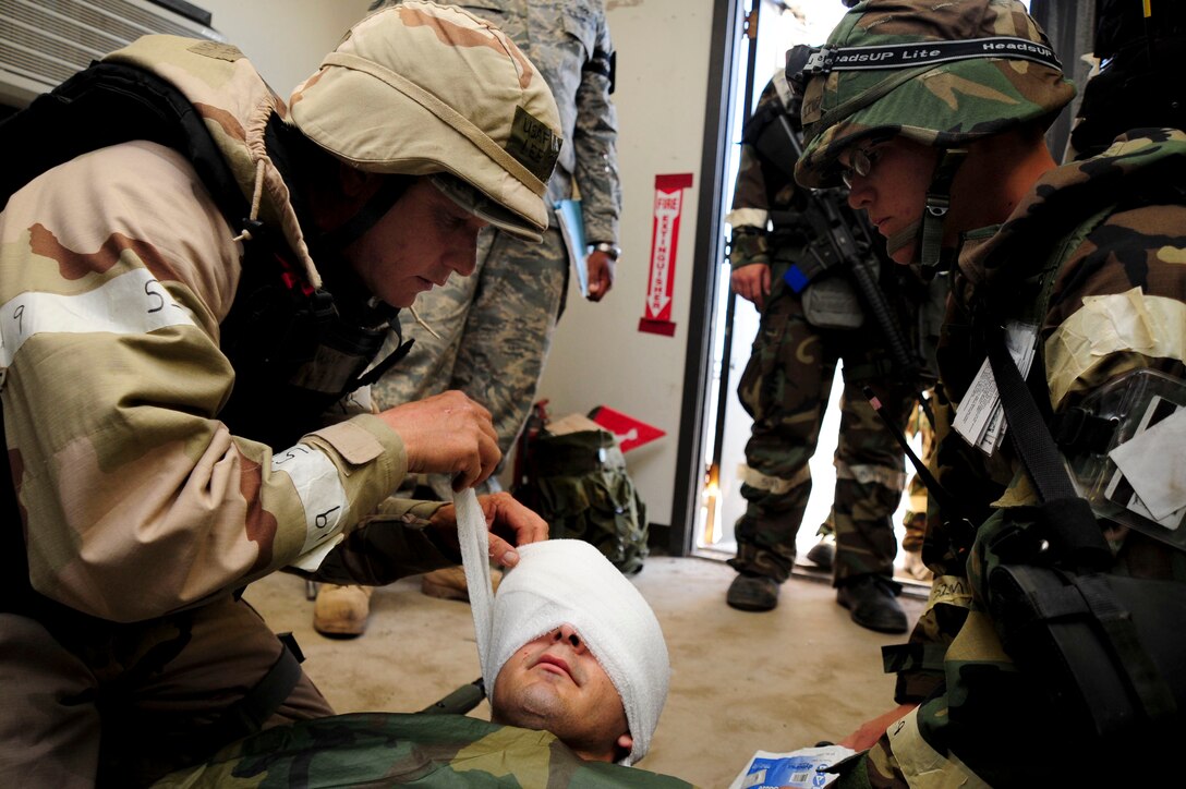 ELLSWORTH AIR FORCE BASE, S.D. – (Left) Master Sgt. Lee Greenwell, water fuel systems craftsman and Airman 1st Class David McMillen, heating, ventilation and air conditioning apprentice, both from the 28th Civil Engineer Squadron, provide self-aid buddy care to Airman 1st Class Frederick Ferrante, Air Force Financial Services Center reserve travel technician, during a Phase II Operational Readiness Exercise, Sept. 16. During the Phase II ORE Airmen are challenged with SABC scenarios to ensure combat readiness. (U.S. Air Force photo/Senior Airman Corey Hook)