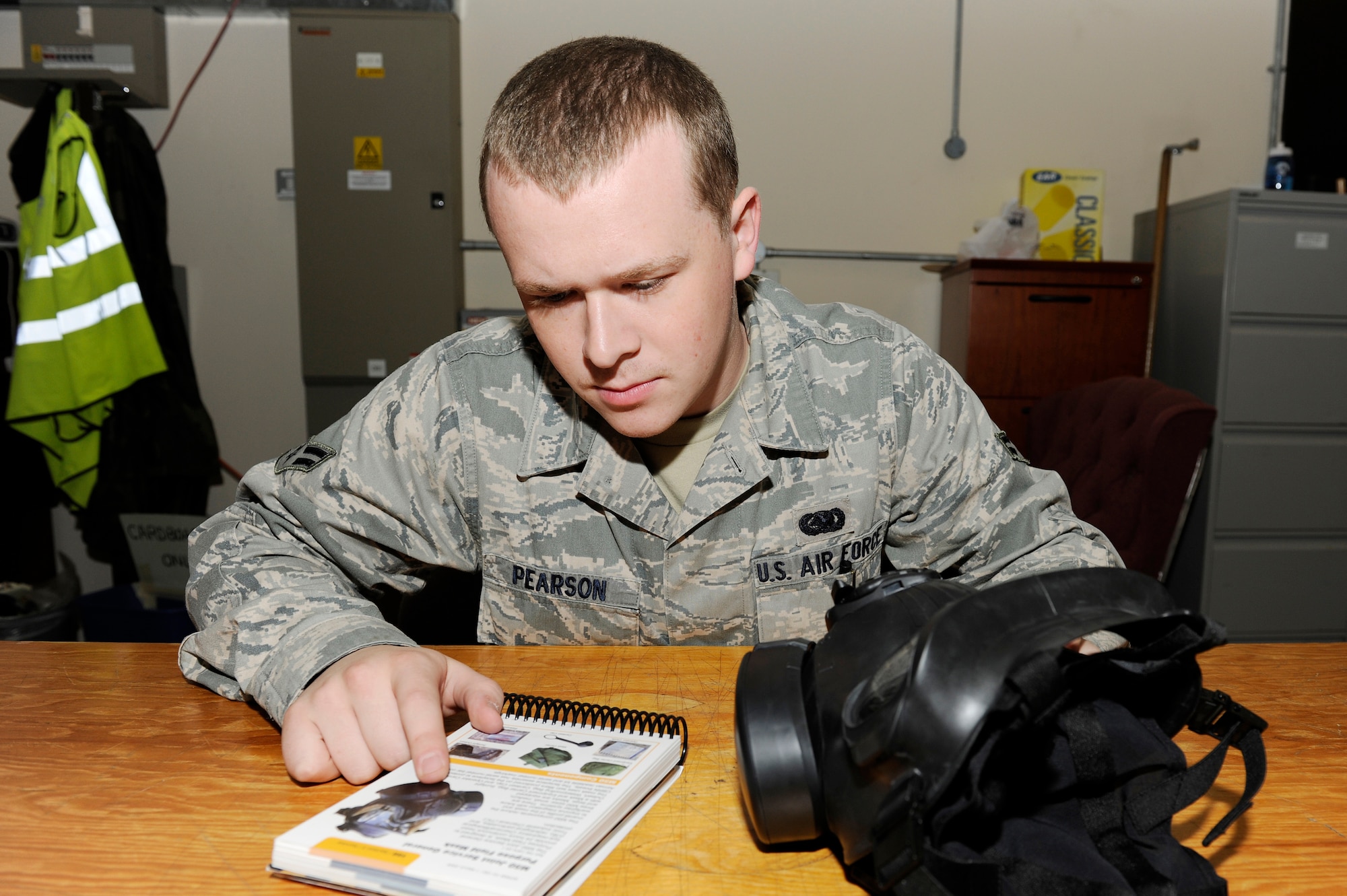 ROYAL AIR FORCE LAKENHEATH, England – Airman 1st Class Guy Pearson, 48th Logistics Readiness Squadron individual protective equipment journeyman, references an Airman’s Manual for guidance regarding the M50 Joint Service General Purpose Field Mask Sept. 22. The M50 was first issued in May 2009 and has been fielded by Pacific Air Force and United States Air Forces in Europe. (U.S. Air Force photo/Airman 1st Class Lausanne Morgan)