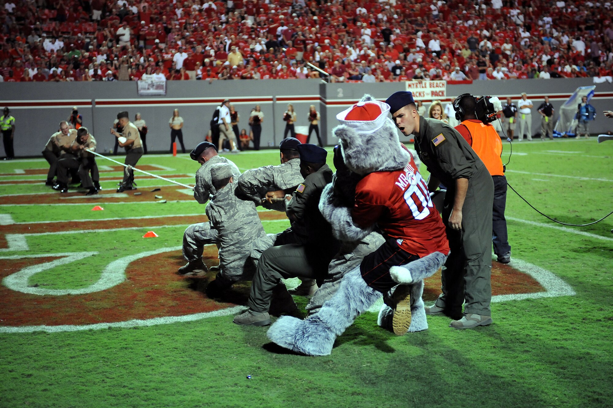 RALEIGH, N.C. – Senior Airman Dusty Cotter encourages fellow Airmen during a tug-of-war competition against Marines from Camp Lejuene at Carter-Finley stadium in Raleigh Sept. 16, 2010. The competition was one of many festivities performed during the N.C. State Military Appreciation Day football game. Airman Cotter, 43rd Aeromedical Evacuation Squadron technician, is stationed at Pope Air Force Base. (U.S. Air Force photo/Master Sgt. Brandt Smith)