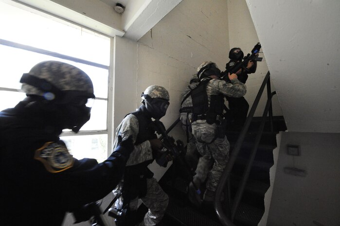 Members of the 628th Security Forces Squadron go up a stairwell to find an aggressor during a mock hostile situation during the active shooter training exercise on Joint Base Charleston, S.C., Sept. 22, 2010. The AST exercise prepares first responders on how to react to a hostile situation. (U.S. Air Force photo by James M. Bowman/released)