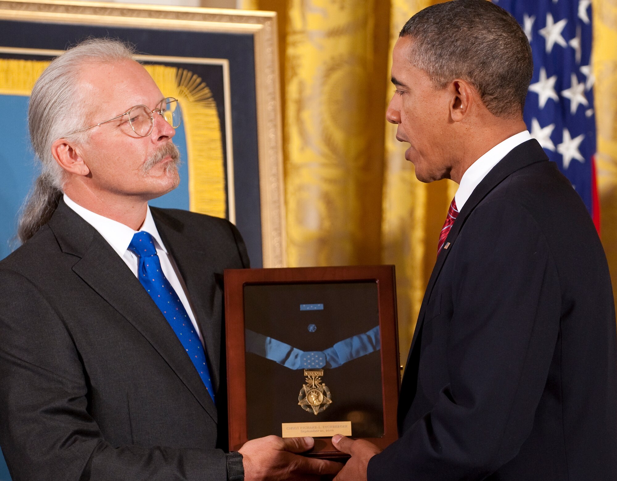President Barack Obama, right, presents a Medal of Honor award to Richard Etchberger, son of U.S. Air Force Chief Master Sgt. Richard L. Etchberger, during a ceremony at the White House Sept. 21, 2010. Richard Etchberger and his brothers, Steve Wilson and Cory Etchberger, all attended the ceremony to accept the posthumous award on behalf of their father, who received the medal for his actions during the Vietnam War. Chief Master Sgt. Etchberger exposed himself to enemy fire in order to save three fellow Airmen during an attack on their position in Laos March 11, 1968. Etchberger suffered fatal wounds after placing the wounded Airmen in rescue slings so they could be airlifted to safety. (U.S. Air Force photo/Jim Varhegyi)