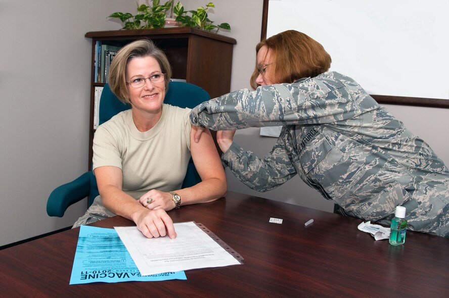 HANSCOM AIR FORCE BASE, Mass. – Col. Stacy L. Yike, 66th Air Base Group commander, receives a flu shot from Staff Sgt. Lori McCarty of the 66th Medical Squadron on Sept. 22. Mandatory flu shots for Electronic Systems Center active duty, Reserve and IMA personnel took place this week at the clinic. (U.S. Air Force photo by Rick Berry)