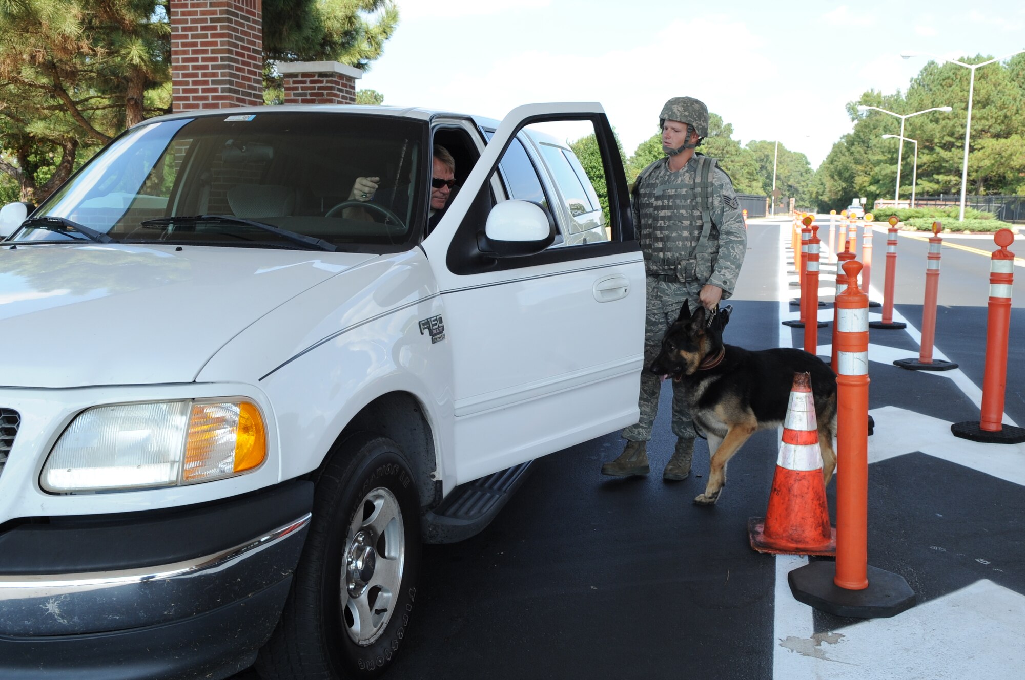 SEYMOUR JOHNSON AIR FORCE BASE, N.C. -- Staff Sgt. Brent Reimers and his military working dog, Rey, perform a vehicle inspection during operation readiness exercise Coronet Warrior 10-6 here Sept. 20, 2010. During the exercise, the base personnel are placed in a wide variety of scenarios and challenged to respond appropriate in a timely manner. Sergeant Reimers is a 4th Security Forces Squadron MWD trainer. (U.S. Air Force photo/Staff Sgt. Courtney Richardson)  