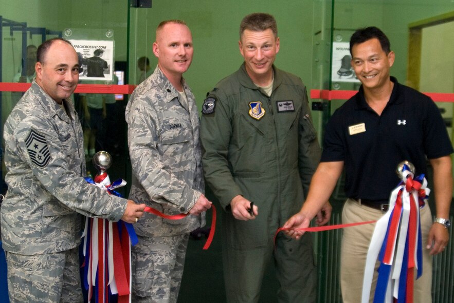 KUNSAN AIR BASE, Republic of Korea -- Col. John Dolan, 8th Fighter Wing commander, cuts the ribbon with base leadership for the brand new CrossFit/Total Resistance Exercise workout room at the base gym Sept. 21.  Both workouts are built to strengthen the entire body and can last anywhere from 15 to 30 minutes. (U.S. Air Force photo/Staff Sgt. Jonathan Pomeroy)
