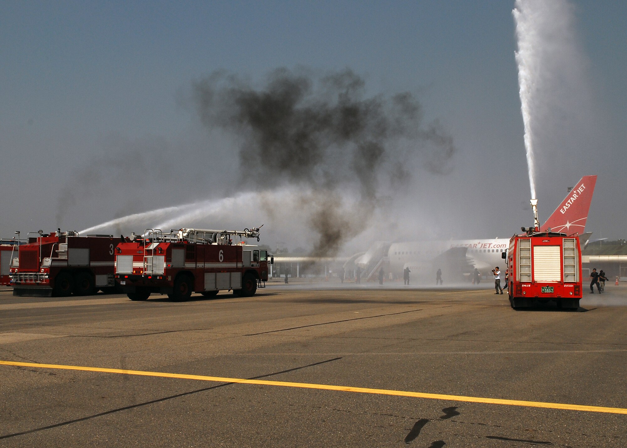 KUNSAN AIR BASE, Republic of Korea -- The 8th Civil Engineer Squadron and Republic of Korea fire departments extinguish a simulated burning aircraft as part of an exercise at the Gunsan airport here Sept. 17, 2010. The exercise is done annually to enhance counter-terrorism and prepare emergency responders for real-life situations. (U.S. Air Force photo/Senior Airman Ciara Wymbs) 
