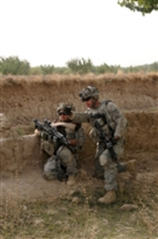 U.S. Army Sgt. John Rogers, of the 1st Battalion, 4th Infantry Regiment, shows a fellow soldier his sector of fire during a presence patrol in the Zabul province of Afghanistan on Sept. 18, 2010.  