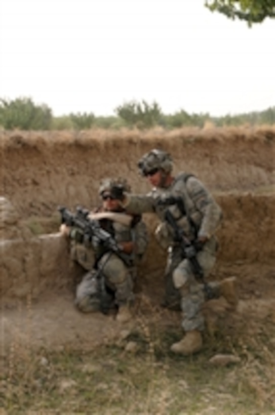 U.S. Army Sgt. John Rogers, of the 1st Battalion, 4th Infantry Regiment, shows a fellow soldier his sector of fire during a presence patrol in the Zabul province of Afghanistan on Sept. 18, 2010.  