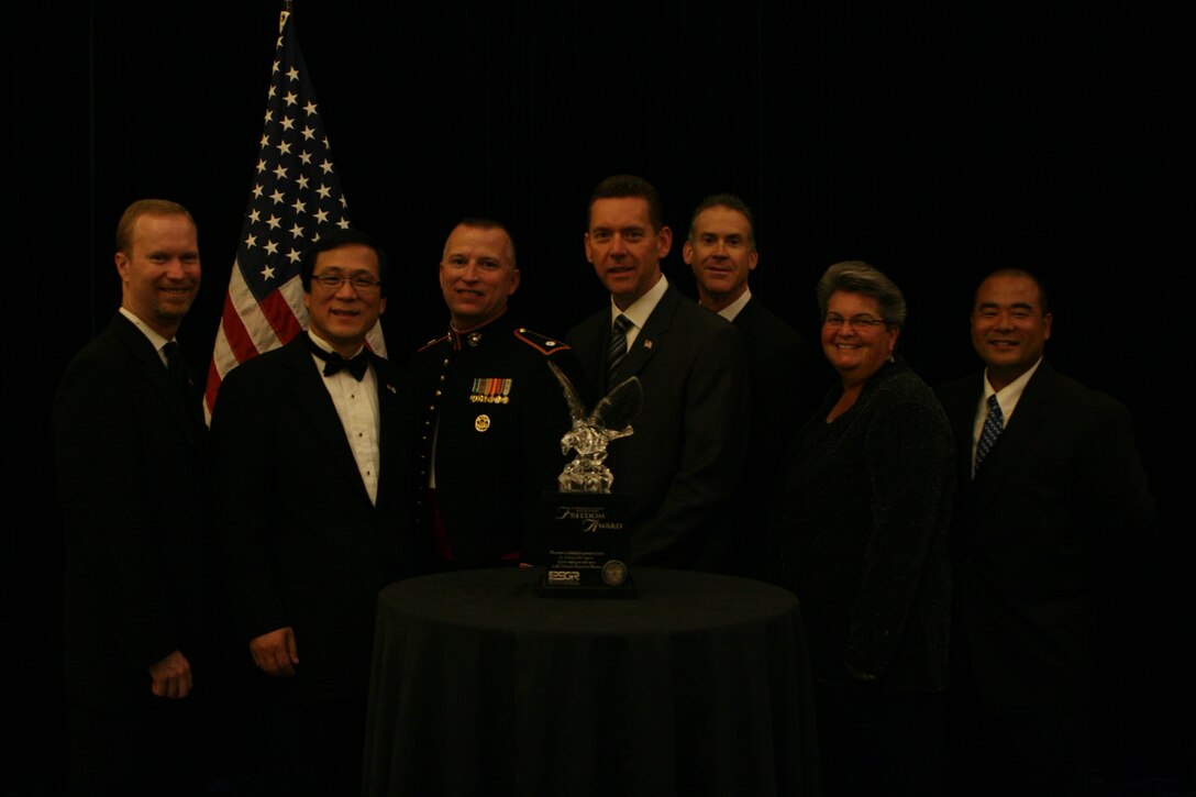 Irivine, Calif. officials including City Manager Sean Joyce, Mayor Sukhee Kang, Police Officer Lt. Col. Thomas Allan, Police Chief David Maggard Jr., Tim Knight, Mya Sanders and Photographer Dan Jung pose for a photo with the Freedom Award. The Freedom Award is given annually to select employers throughout the continental U.S., Guam, Puerto Rico and the Virgin Islands to qualified employers who show outstanding support to employees who serve in the Reserve and Guard.  The Secretary of Defense, Robert Gates, approves the final winners of the Freedom Award.