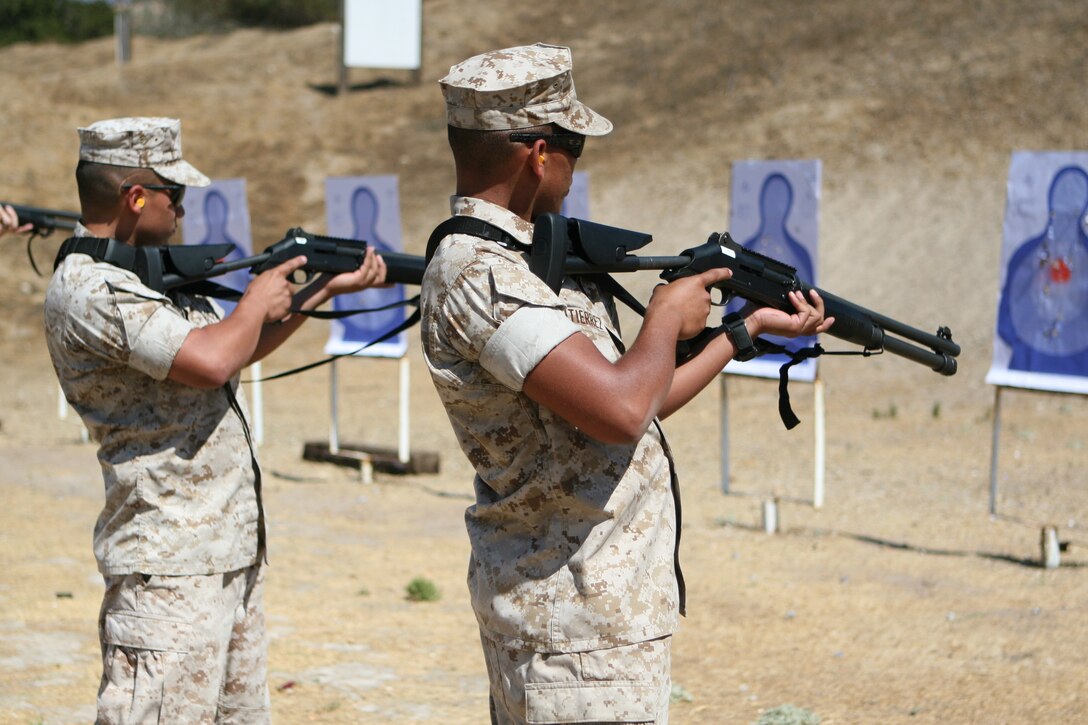 Lance Cpls. Douglas Gutierrez and Andres Juarez, both participants of the Security Augment Force training course, finish firing the M1014 semi-automatic shotgun during a live-fire training exercise Sept. 23. Each participant fired from distances up to 20 yards.