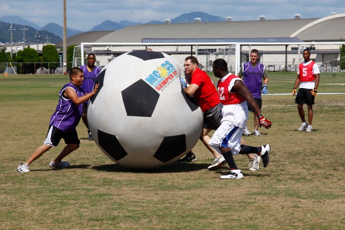Participants with Combat Logistics Company 36 and Marine Wing Support Squadron 171 battle for possession of a nearly six-foot tall soccer ball during the second to last Commander’s Cup Challenge called Earthball at the Penny Lake soccer fields here Sept. 24.