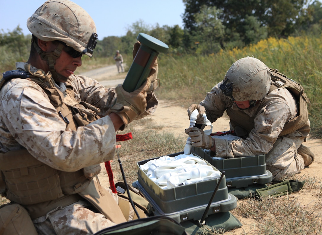 Cpl. Alex A. Avila (left) and Lance Cpl. William F. Redenius both combat engineers with 2nd Combat engineer battalion attached to Company E, 2nd Battalion, 8th Marine Regiment set up an APOB (anti-personnel, obstacle-breaching system) during a company-sized attack on range 24, here, recently.  The engineers held an essential role in the exercise by clearing a simulated mine field.