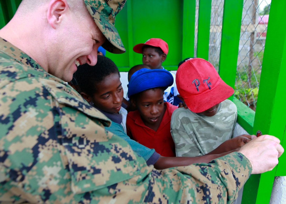 U.S. Marine Lt. Col. Chris S. Richie, commanding officer of Special-Purpose Marine Air-Ground Task Force Continuing Promise 2010 (CP10), with the help of local Nicaraguan children, places a Marine Corps sticker on the dugout of a baseball field after renovations by Marines and Sailors, in Bluefields, Nicaragua, Sept. 24, 2010. Service members and civilians are deployed in support of CP10 providing medical, dental, veterinary, engineering assistance and subject-matter exchanges to the Caribbean, Central and South America. (U.S. Marine Corps photo by Sgt. Samuel R. Beyers/Released)