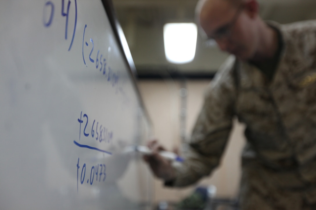 Lieutenant j.g. Jeffrey Cummings, naval gunfire liaison officer for Battalion Landing Team 3/8, 26th Marine Expeditionary Unit, writes equations on a dry erase board during a math class conducted through Park University aboard USS Kearsarge in the U.S. Navy Fifth Fleet Area of Operation, Sept. 24, 2010. 26th MEU continues to support relief operations in Pakistan and is also serving as the theater reserve force as elements of the MEU conduct training and planned exercises.