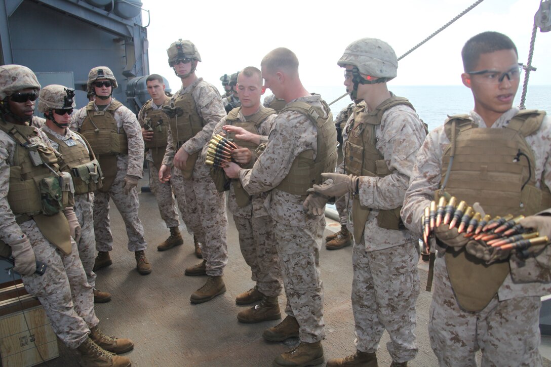 Marines with Company L, Battalion Landing Team 3/8, 26th Marine Expeditionary Unit, distribute rounds prior to a M2 .50 caliber machine gun fire exercise on the foc'sle aboard USS Carter Hall in the U.S. Navy 5th Fleet Area of Responsibility, Sept.  24, 2010. 26th MEU continues to support relief operations in Pakistan and is also serving as the theater reserve force as elements of the MEU conduct training and planned exercises.