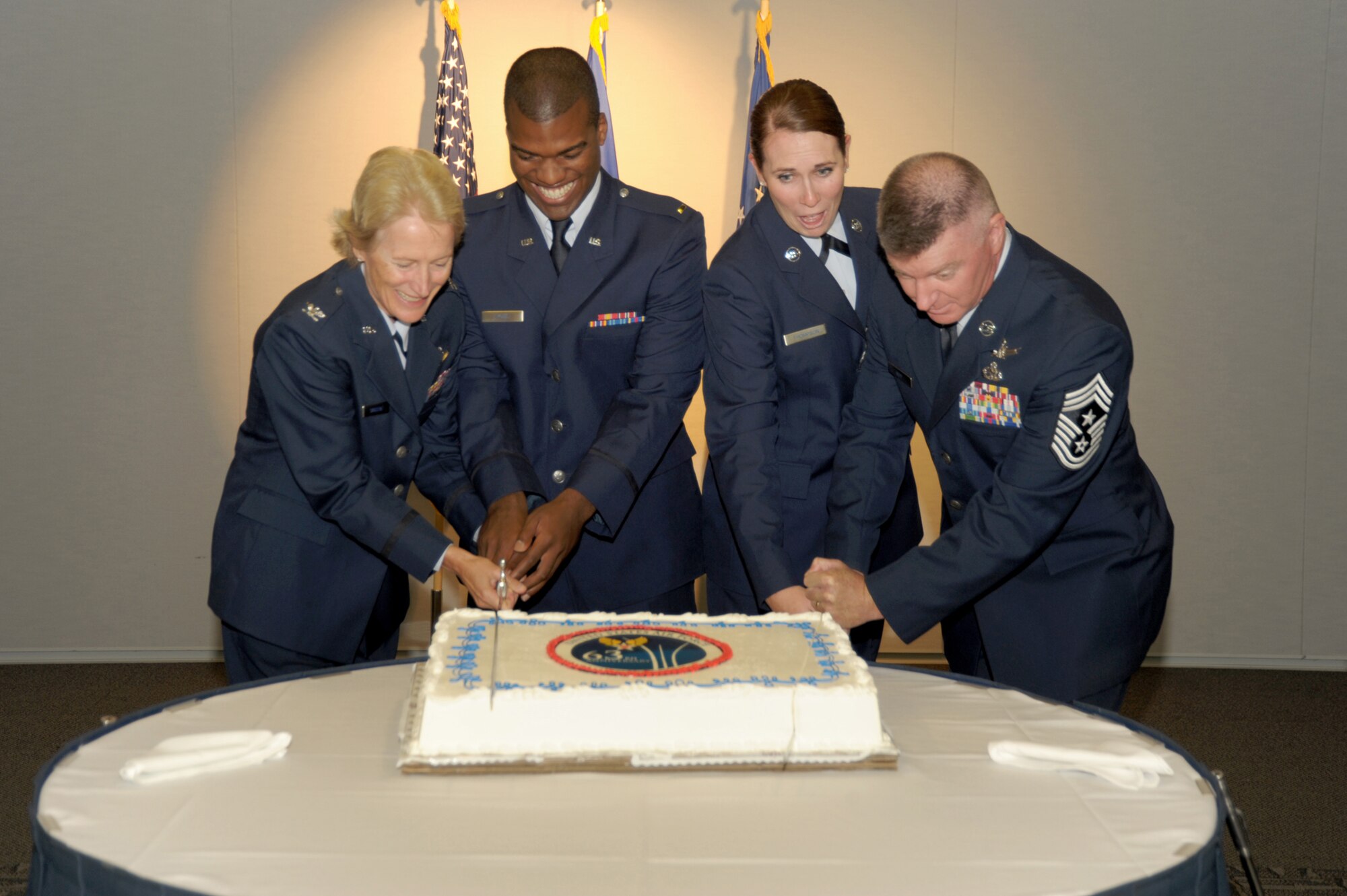 Colonel Joan Sandene, SMC commander IMA, and Chief Master Sgt. Mark Repp, SMC’s command chief master sergeant, are joined by  Los Angeles AFB’s youngest officer and youngest enlisted person in cutting the cake celebrating the Air Force's 63rd Birthday, Sept. 17. (Photo by Joe Juarez)