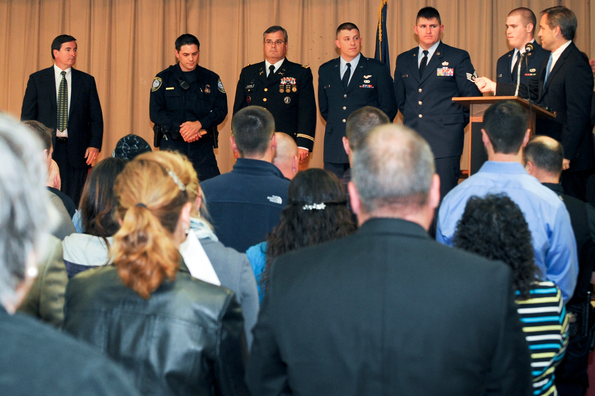 ANCHORAGE, Alaska -- From left to right, Anchorage Police Department Officer Chris Heitsuman, Army Lt. Col. Peter Savage, Air Force Capt. Erik Boltman, Air Force Staff Sgt.Jacob Gibson and Airman 1st Class Spencer Stringer, receive a standing ovation from Gov. Sean Parnell, Mayor Dan Sullivan and the audience in attendance for their heroic acts during a plane crash in Anchorage earlier this year, during an award ceremony that honored all those who helped during the incident. The service members were some of the first on scene alongside first responders from the local community and aided in the rescue of four survivors. Each person honored, received a plaque from the governor. (Air Force photo by Staff Sgt. Joshua Garcia)