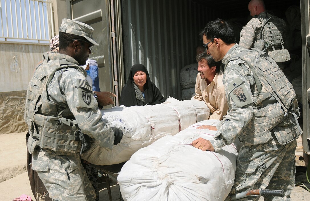 Soldiers from the 1st Battalion, 101st Field Artillery Regiment of the Massachusetts Army National Guard assist a family with tents and food supplies during the delivery of humanitarian aid in the Dasht Barchi village of Kabul, Afghanistan, Sept. 23, 2010. Defense officials are working to determine the role going forward for the nation's reserve-component forces. (U.S. Army photo/Capt. Anthony Deiss)  
