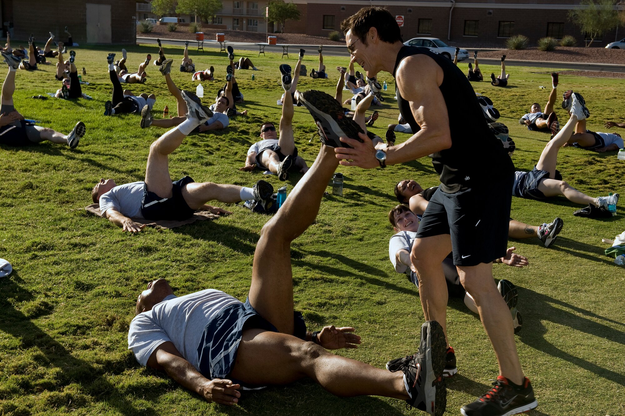 NELLIS AIR FORCE BASE, Nev.-- Fitness trainer Tony Horton assists Maj. Charles Gates, a security forces officer assigned to the 561st Joint Tactics squadron, with a scissor-kick exercise at the Nellis Sports Pavilion, Sept. 24. Mr. Horton developed a fitness system has been used by military members from around the world. (U.S. Air Force photo by Senior Airman Brett Clashman/Released)
