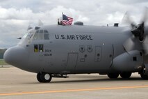 YOUNGSTOWN AIR RESERVE STATION, Ohio -- An Airman assigned to Air Force Reserve Command?s 910th Airlift Wing waves an American flag from the top hatch of a C-130H Hercules tactical cargo aircraft upon arrival here, September 17. Approximately 60 Citizen Airmen returned to the Mahoning Valley following a 120-day deployment to Germany. The aircrews and maintenance personnel were providing airlift support for U.S. Africa Command. U.S. Air Force photo by Master Sgt. Bob Barko Jr.