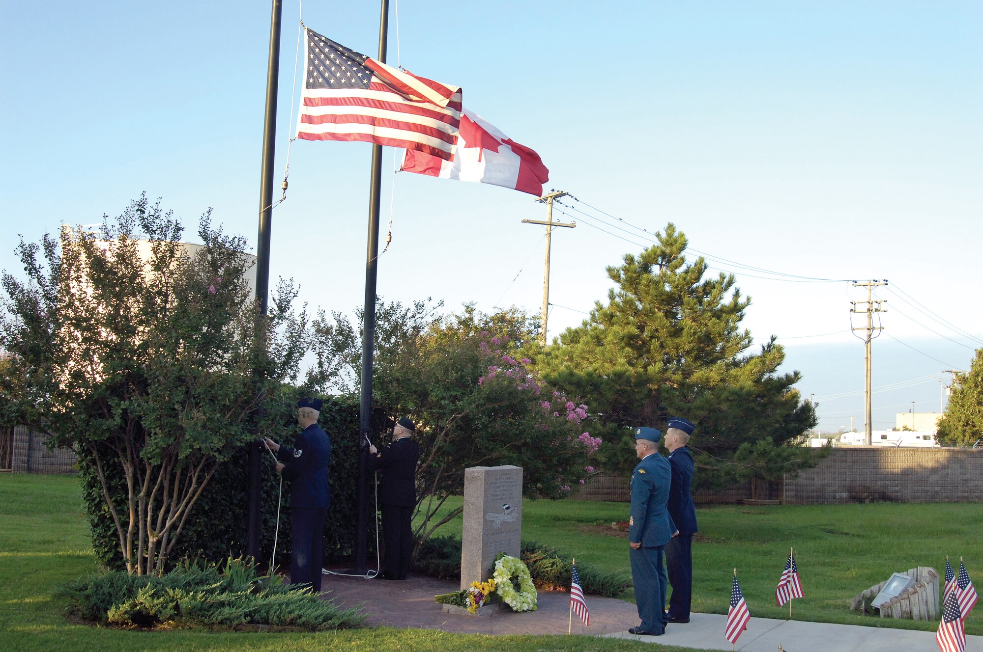 Canadian Detachment Chief Warrant Officer Richard Nadeau and U.S. Air Force Col. Scott Forest, 552nd Air Control Wing vice commander, salute the flags after laying a wreath Sept. 22 during a YUKLA 27 memorial ceremony at Tinker. Family and 552nd ACW members attended the solemn ceremony to honor the 24-member crew who died after the E-3 Sentry crashed during takeoff from Elmendorf Air Force Base, Alaska, in 1995.  Tinker’s memorial, located near the “Connie” aircraft static display near Bldg. 469, was dedicated in 1996, one year after the fatal crash.  (Air Force photo by Margo Wright)