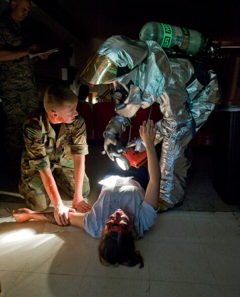 BARKSDALE AIR FORCE BASE, La.-- A firefighter assigned to the 2nd Civil Engineer Squadron provides aid to simulated casualties at the base theater as part of a scenario during a nuclear surety exercise Sept. 24. The NSE is designed to ensure Barksdale's ability to execute nuclear operations in a safe, secure and reliable manner. (U.S. Air Force photo/Senior Airman Chad Warren)