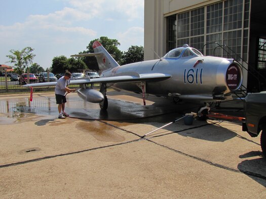 Maj. Gil Griffin, cousin of pilot Randy Ball and an ACSC student, washes the MiG-17F before its trip from Maxwell-Gunter to Offutt Air Force Base, Neb. The MiG had been at Maxwell since the March air show. (Air Force photo/Carl Bergquist)