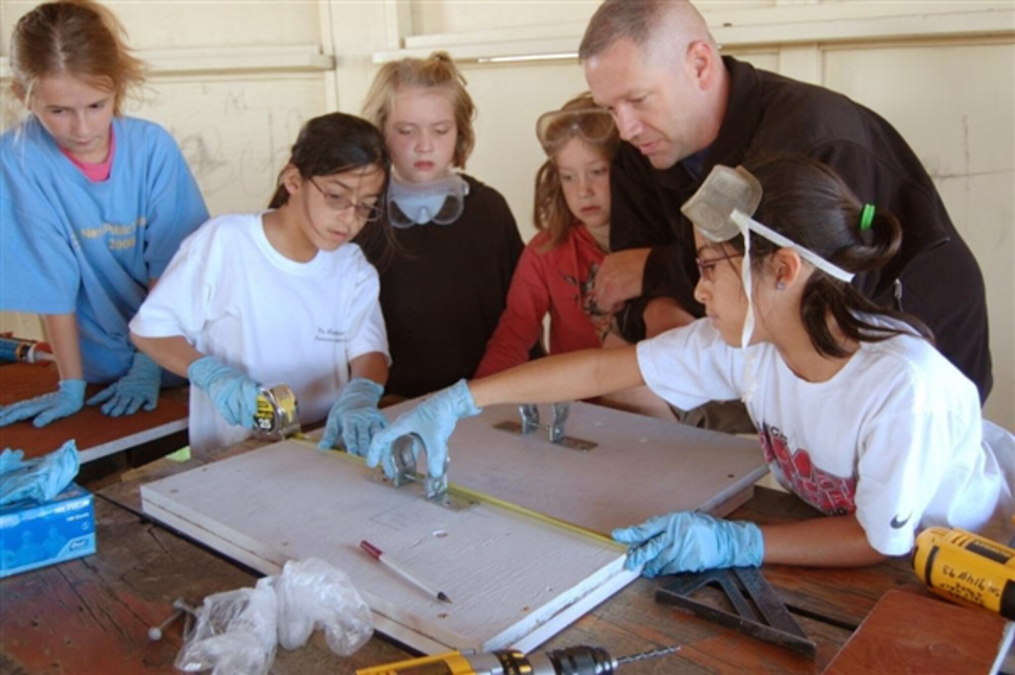 An Airman leads children in constructing a bat box as part of volunteer conservation efforts on National Public Lands Day Sept. 25, 2009, at Malmstrom Air Force Base, Mont. (U.S. Air Force photo) 