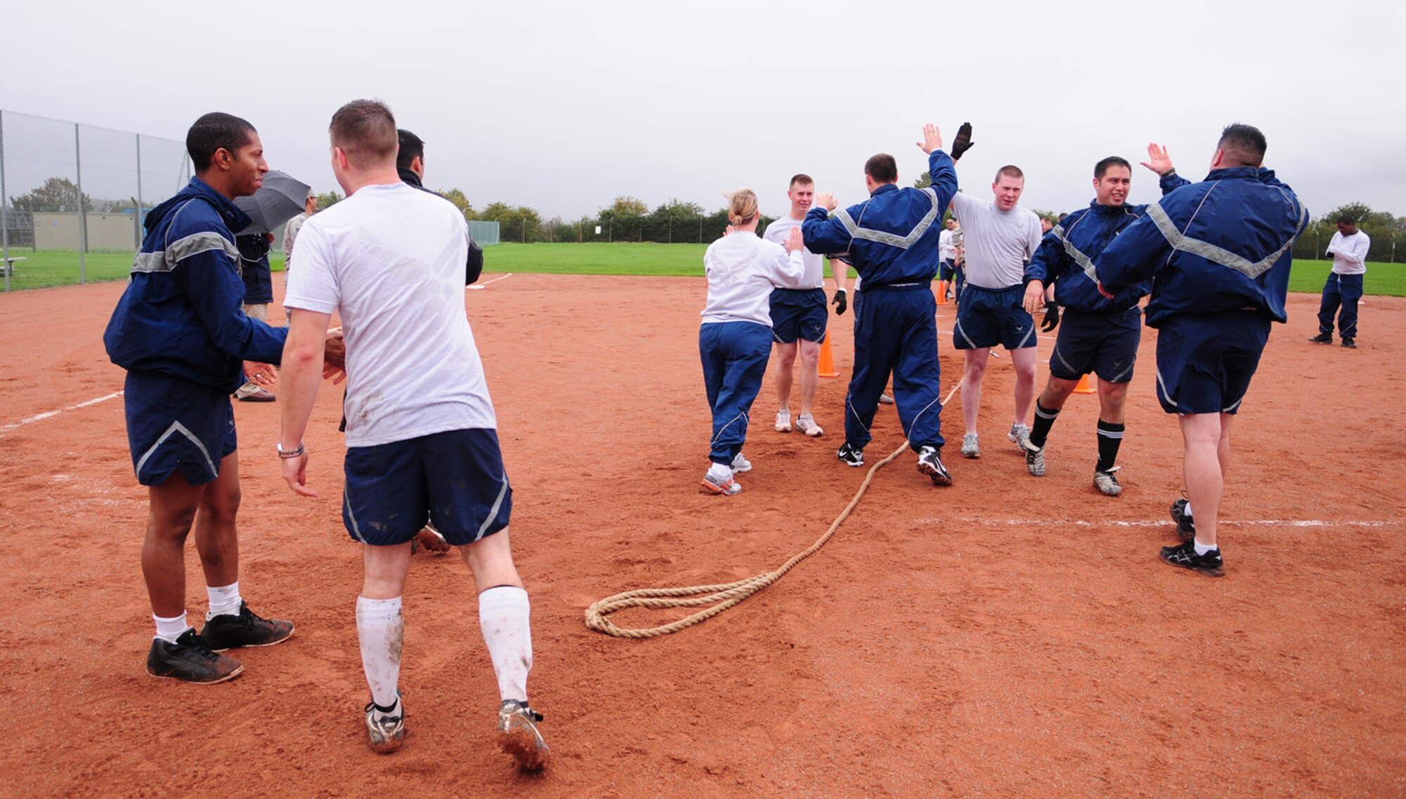 RAF MILDENHALL, England -- The 488th Intelligence Squadron team congratulate each other on their easy win at the tug-of-war event Sept. 24 at the softball field next to the Hardstand Fitness Center. Wing Sports Day consisted of many other events including 3-on-3 basketball, volleyball, soccer, ultimate football and bowling. (U.S. Air Force photo/Karen Abeyasekere)