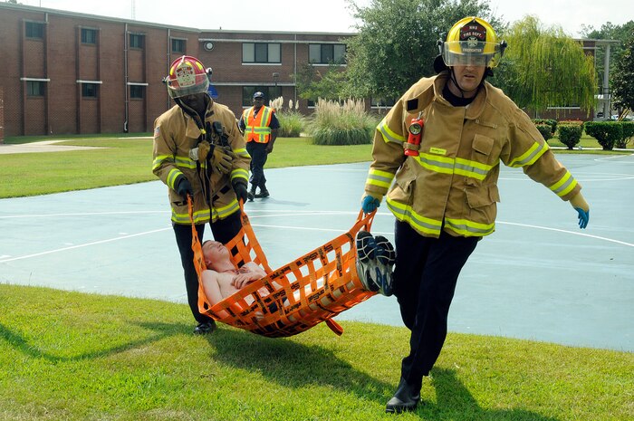 Fireman Eric Kelly, right, from Detriot, Mich., and Capt. Stanley Brown transport a victim who received a simulated gunshot wound to the chest during a base-wide active shooter exercise on Naval Weapons Station Charleston Sept. 22, 2010. The exercise was held as a joint effort between Air Force and Navy personnel to build the working relationship between both services operating as one team on Joint Base Charleston. Both Fireman Kelly and Captain Brown are with the NWS Charleston fire department. (U.S. Navy photo/Mass Communication Specialist 1st Class Jennifer R. Hudson/released)