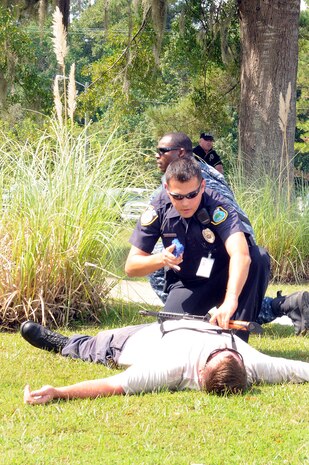 Patrolman Benjamin Mcswain, front, from Gastonia, N.C., and Master-at-Arms 2nd Class Sherman Widbee from Richmond, Va., disarm a simulated aggressor, played by Firearms Instructor J.D. Rowe from Natchez, Mo., during a base-wide active shooter exercise on Naval Weapons Station Charleston Sept. 22, 2010. All three are assigned to the Naval Weapons Station Charleston security department. (U.S. Navy photo/Mass Communication Specialist 1st Class Jennifer R. Hudson/released)