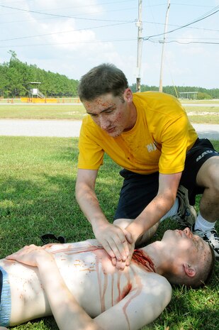 Seaman Richard Contant from Falls Church, Va., simulates emergency first aid on Seaman Recruit Will McKenzaie from Clovis, Calif., who was a victim of an active shooter during a base-wide exercise on Naval Weapons Station Charleston Sept. 22, 2010. The exercise was held as a joint effort between Air Force and Navy personnel to build the working relationship between both services operating as one team on Joint Base Charleston. (U.S. Navy photo/Mass Communication Specialist 1st Class Jennifer R. Hudson/released)