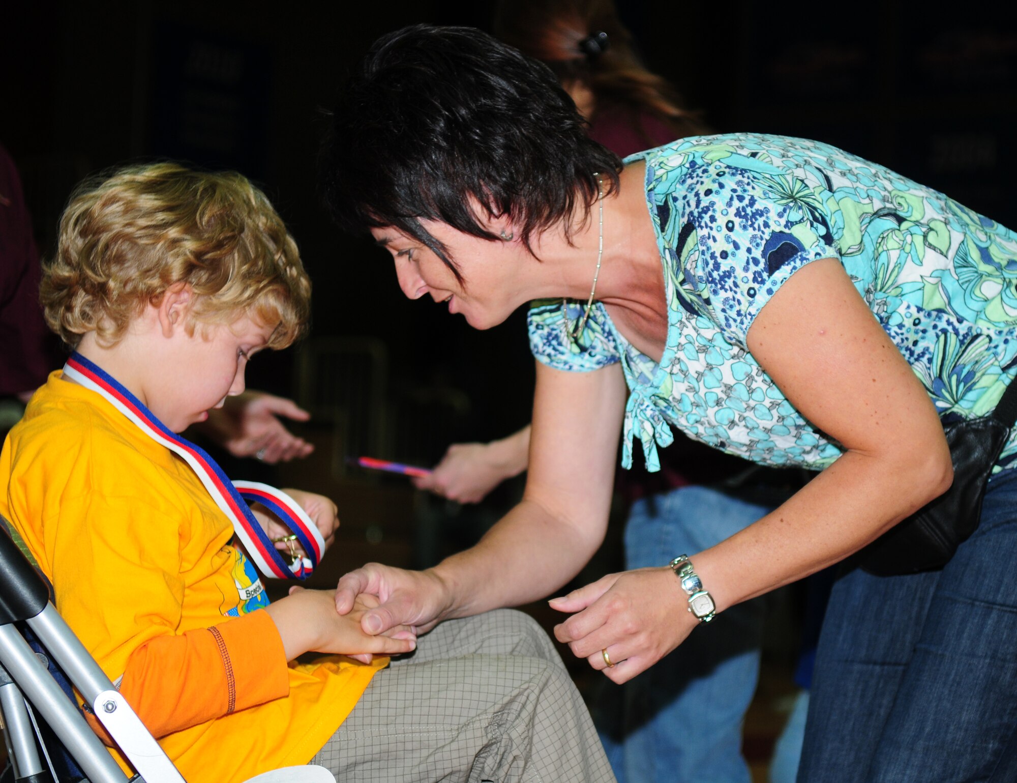 SPANGDAHLEM AIR BASE, Germany – Lydia Oeffling, an event coordinator, presents a medal to a child from a nearby school during the closing ceremony of 15th annual St. Martin’s Special Children’s Day Sept 23.  Approximately 100 children participated in sporting events, song demonstrations, a basketball game and a cookout as part of the event aimed at fun for the children and strengthening community relationships.    (U.S.  Air Force photo/Staff Sgt. Heather M. Norris)