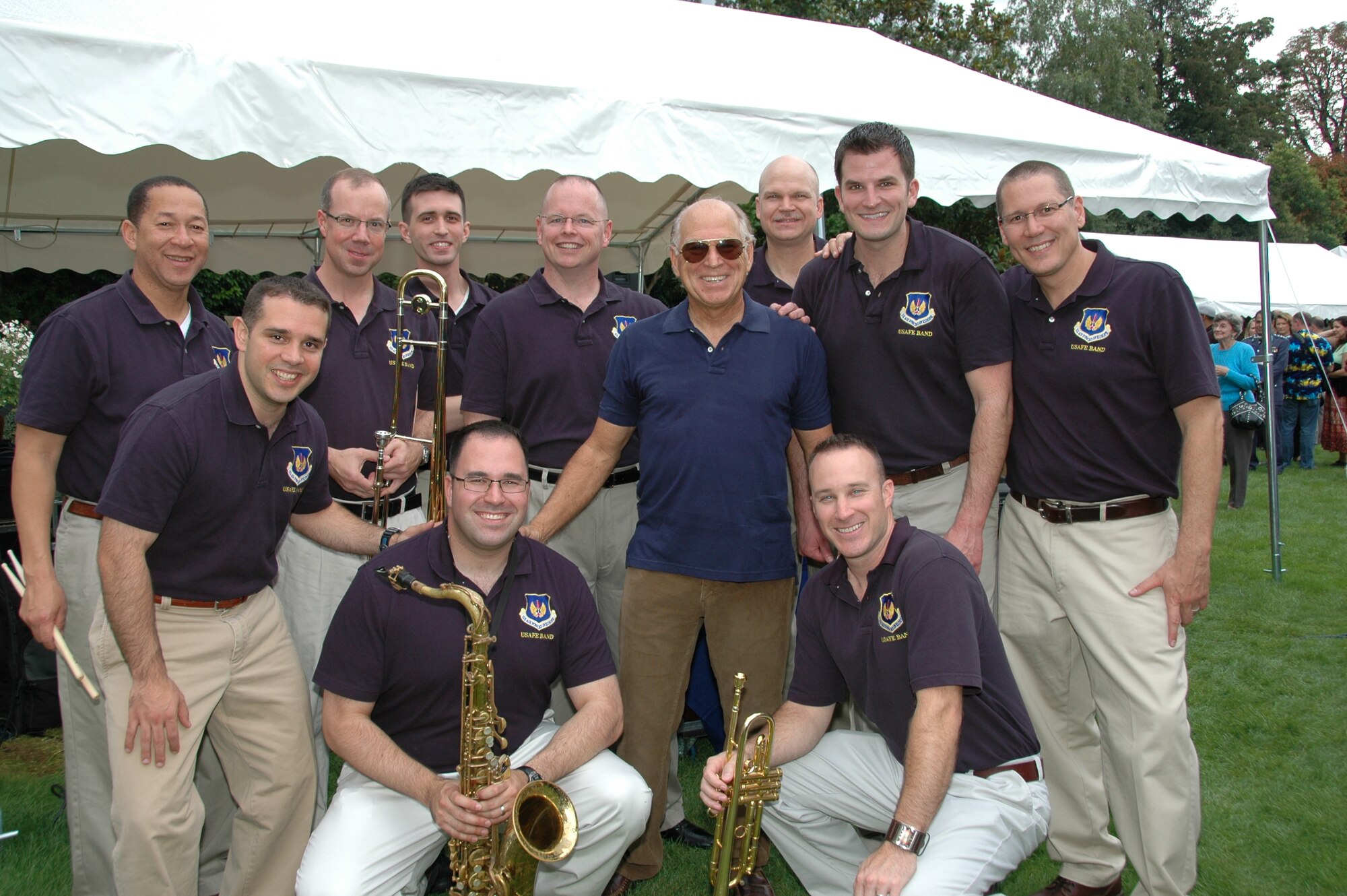 PARIS -- Members of the U.S. Air Forces in Europe Band "Direct Hit" take advantage of a photo opportunity with Grammy award winning recording artist Jimmy Buffett after a performance at the U.S. Embassy-Paris Sept. 23, 2010. Direct Hit provided entertainment support to the embassy for its annual Rentree Barbecue. Mr. Buffett was a guest of honor at the event and also performed some of his hits with the USAFE Band. (U.S. Air Force photo/Staff Sgt. Craig Bowman)