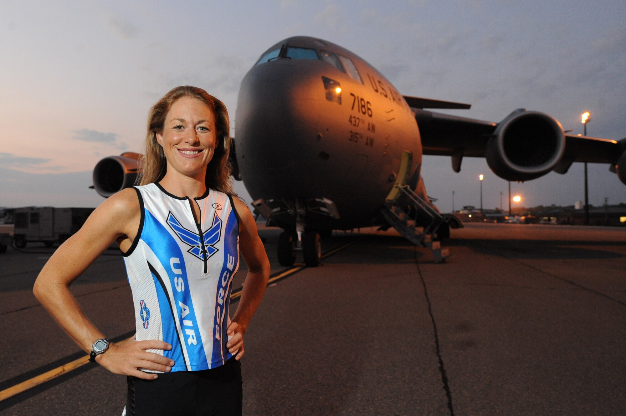 U.S. Air Force Capt. Jamie Turner, wearing her Air Force Ironman uniform, stands in front of a C-17 Globemaster III on Joint Base Charleston, S.C., Sept. 21, 2010. Captain Turner is training to swim 2.4-miles through ocean waves, bike 112 miles and run a 26.2-mile marathon through challenging lava-covered terrain. Selected as one of 1,800 Ironman World Championship competitors, she will test her endurance in one of the top athletic challenges the sports world has to offer. Captain Turner is a pilot with the 315th Airlift Wing. (U.S. Air Force photo/James M. Bowman)